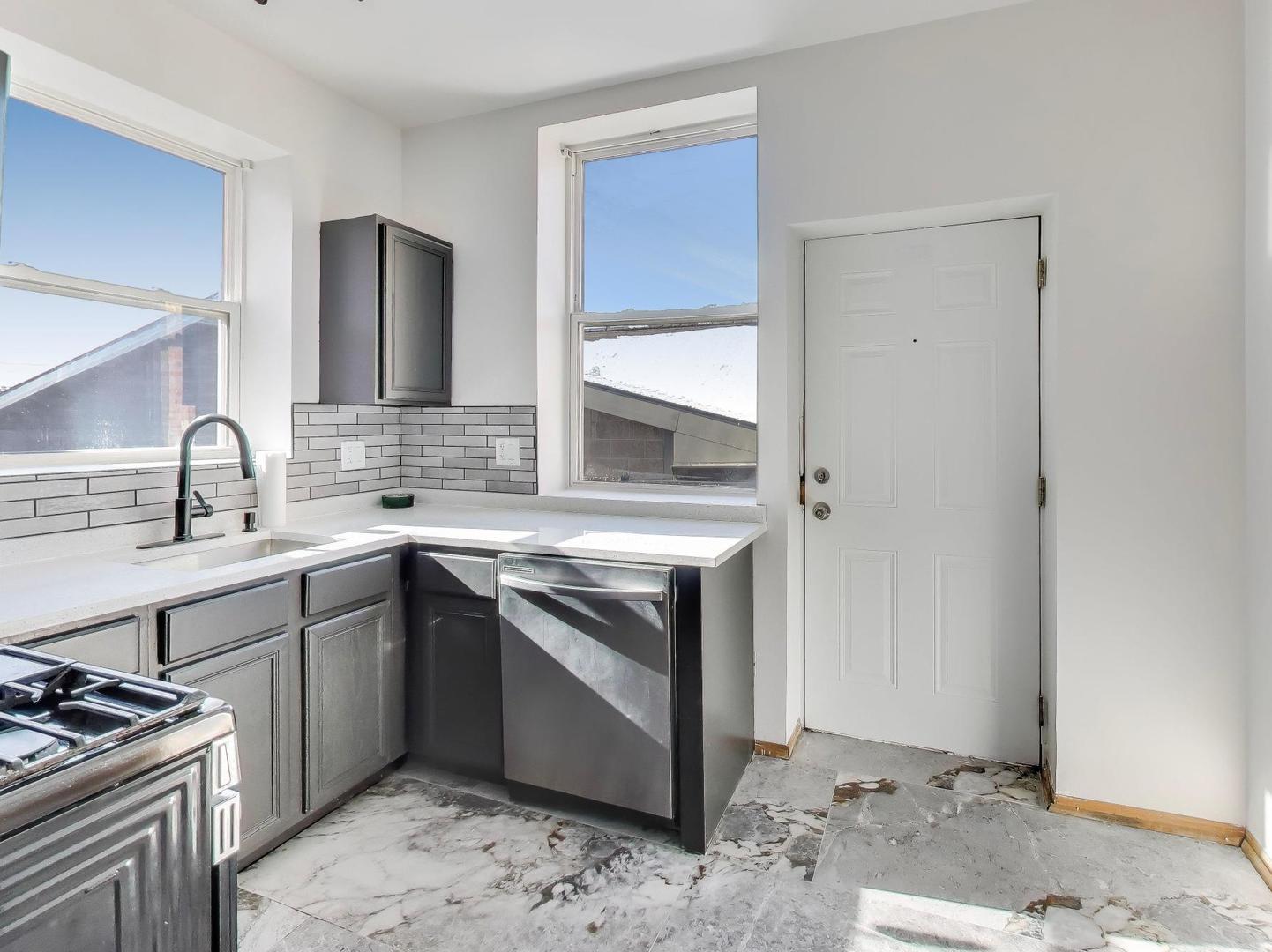 5000 South Champlain Avenue, Unit 3 Chicago, IL 60615 - Photo 7 of 17 a kitchen with a stove sink and cabinets