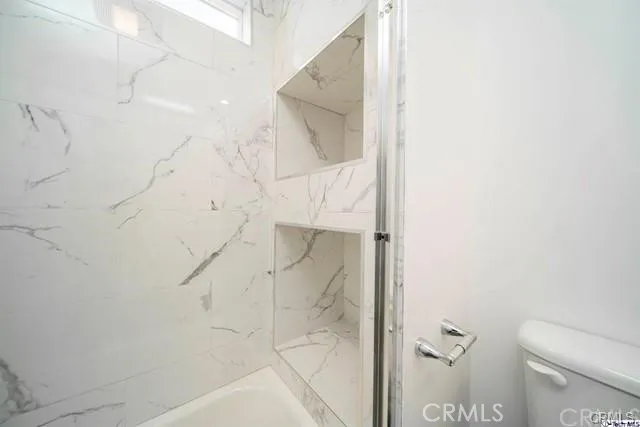 a bathroom with a shower and toilet