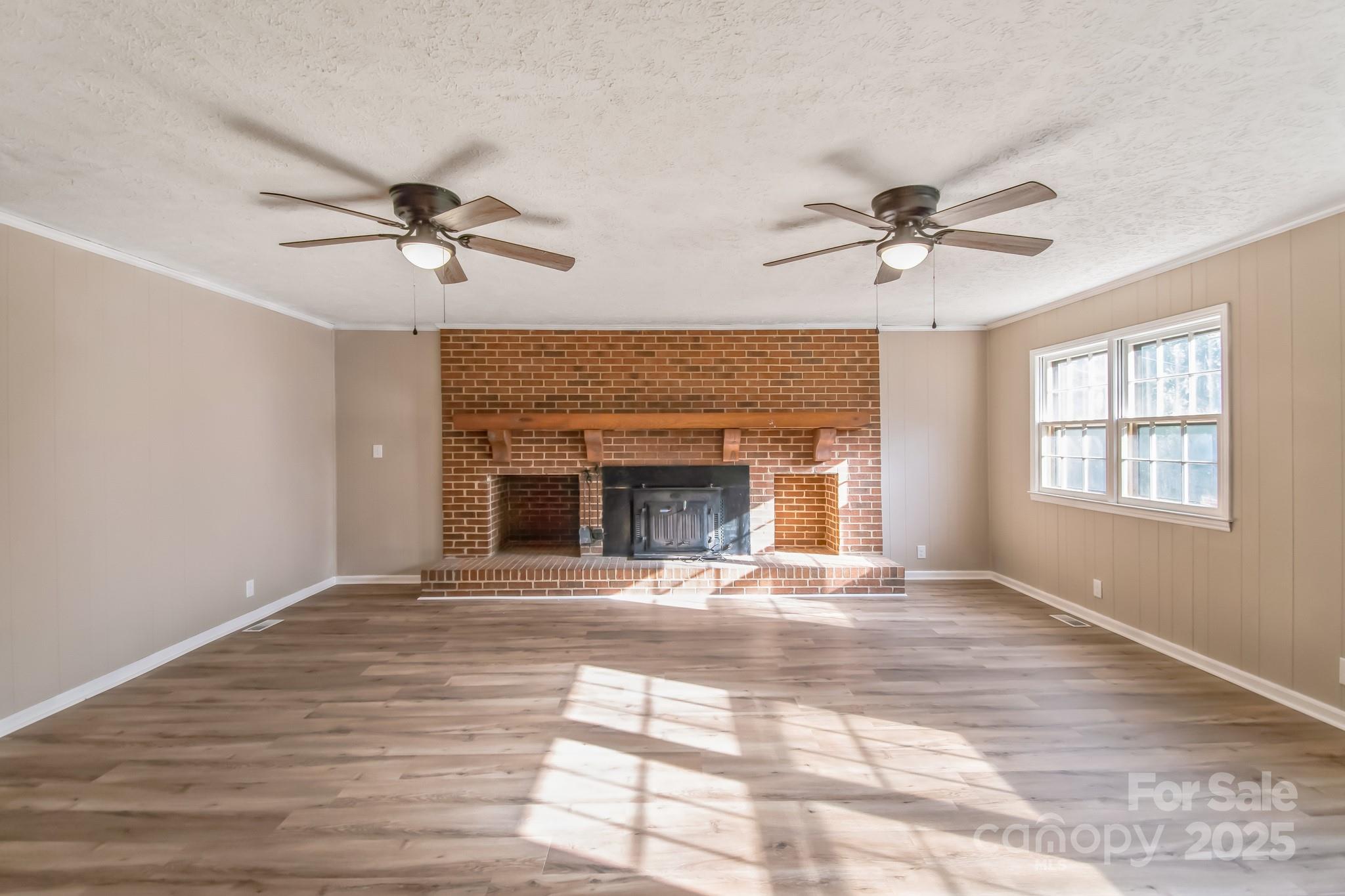 407 Covington Street Rockingham, NC 28379 - Photo 3 of 31 a view of an empty room with a fireplace and a window