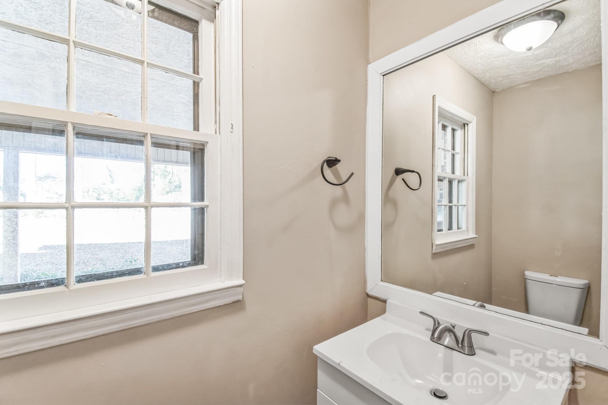 407 Covington Street Rockingham, NC 28379 - Photo 5 of 31 a bathroom with a sink and a large mirror