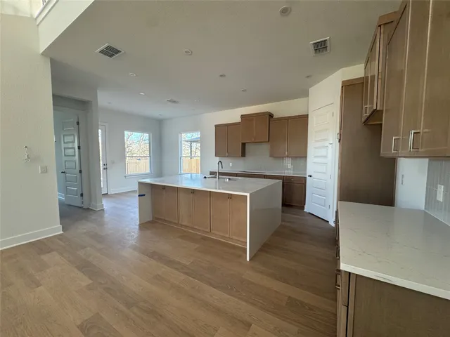 a large kitchen with a center island and stainless steel appliances