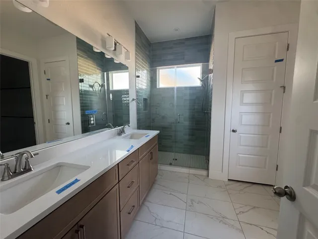 a bathroom with a granite countertop sink mirror and shower