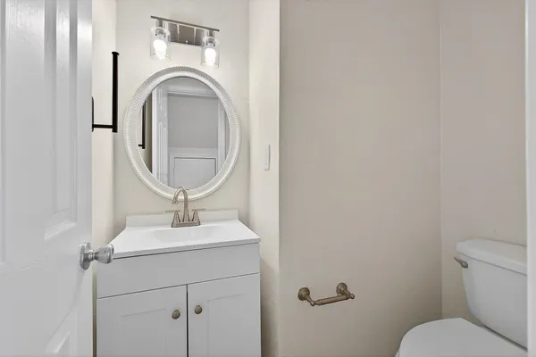 a bathroom with a toilet and a mirror