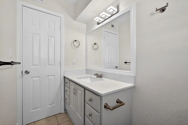 a bathroom with a sink vanity and a mirror