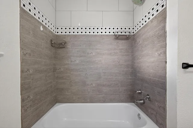 a bathroom with a white bath tub and a shower