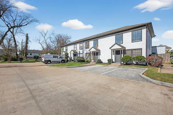 a front view of a building with cars parked