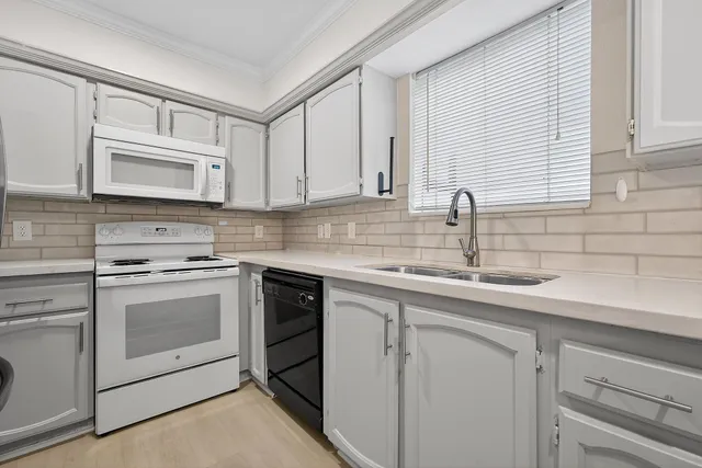 a kitchen with white cabinets stainless steel appliances and sink