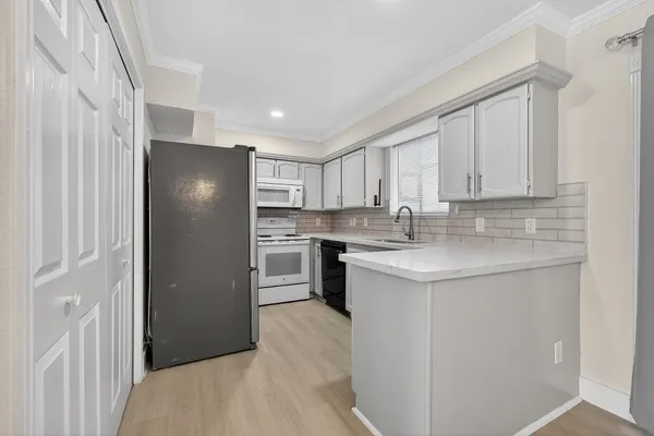 a kitchen with stainless steel appliances granite countertop a refrigerator and a stove top oven