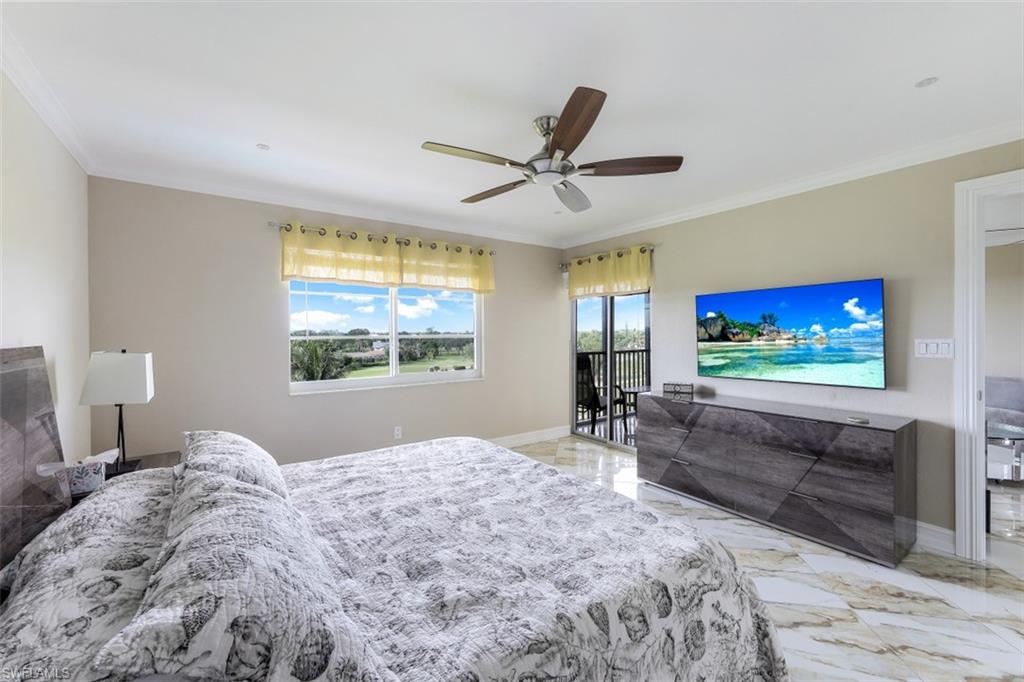 190 Pebble Beach Boulevard, Unit 502 Naples, FL 34113 - Photo 12 of 21 a bedroom with a bed and a flat screen tv