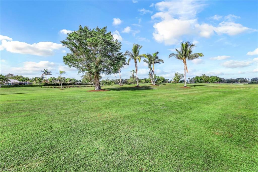190 Pebble Beach Boulevard, Unit 502 Naples, FL 34113 - Photo 18 of 21 a view of a golf course with a big yard