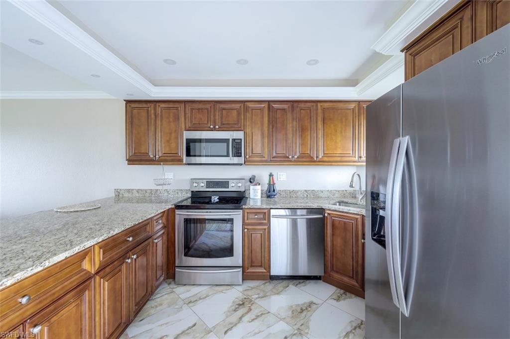 190 Pebble Beach Boulevard, Unit 502 Naples, FL 34113 - Photo 4 of 21 a kitchen with stainless steel appliances granite countertop a stove top oven a sink and dishwasher