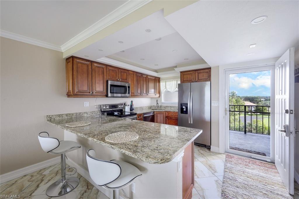 190 Pebble Beach Boulevard, Unit 502 Naples, FL 34113 - Photo 5 of 21 a kitchen with sink a refrigerator and chairs