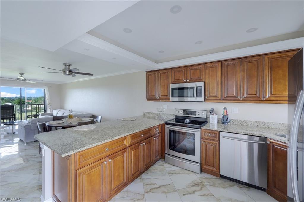 190 Pebble Beach Boulevard, Unit 502 Naples, FL 34113 - Photo 6 of 21 a kitchen with stainless steel appliances granite countertop a stove a sink dishwasher and a refrigerator
