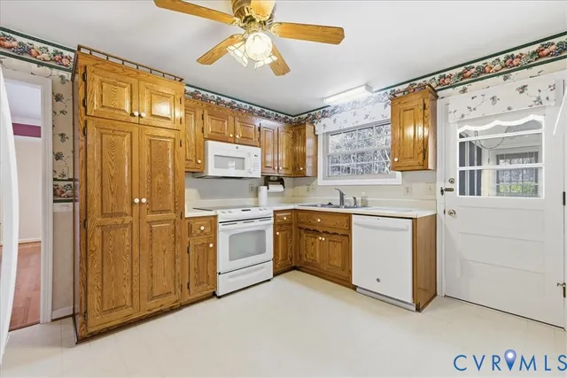 a kitchen with stainless steel appliances granite countertop a refrigerator a sink and white cabinets