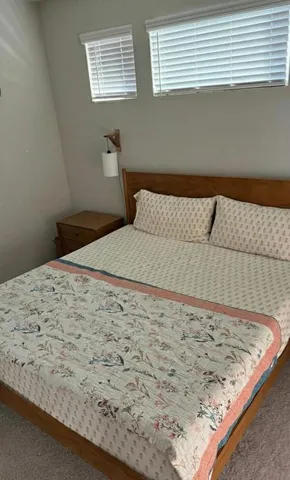 a bed sitting in a bedroom next to a window