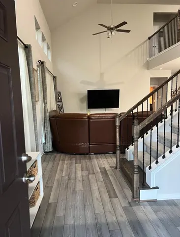 a view of a livingroom with wooden floor and staircase