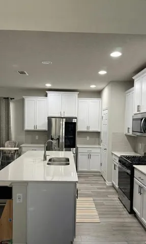 a kitchen with kitchen island sink stove and refrigerator