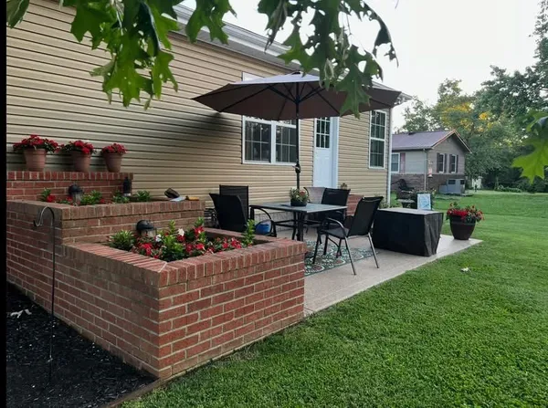 a view of a house with backyard and sitting area