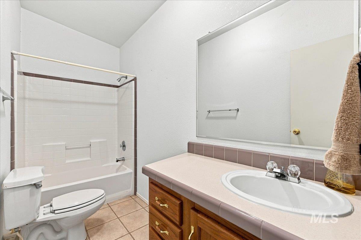 310 Frontage Road Grand View, ID 83624 - Photo 24 of 38 Bathroom featuring a single vanity with built-in cabinetry, an integrated sink, a large wall-mounted mirror, and a full bathtub with a shower system