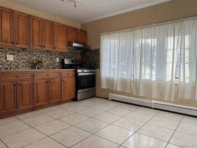 a kitchen with granite countertop a refrigerator sink and cabinets