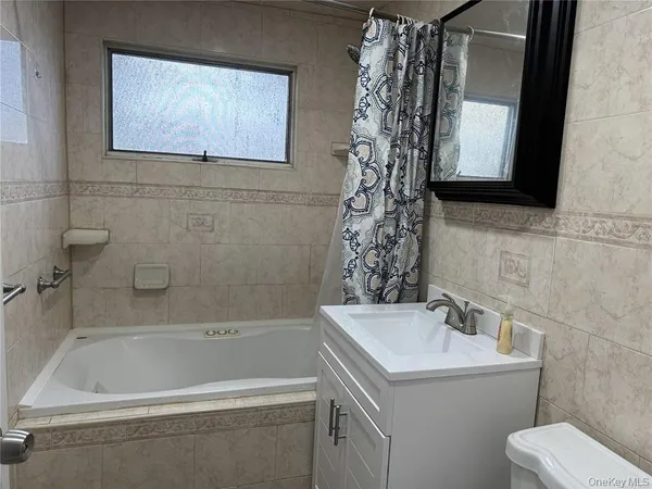 a white bath tub sitting next to a white sink and a toilet