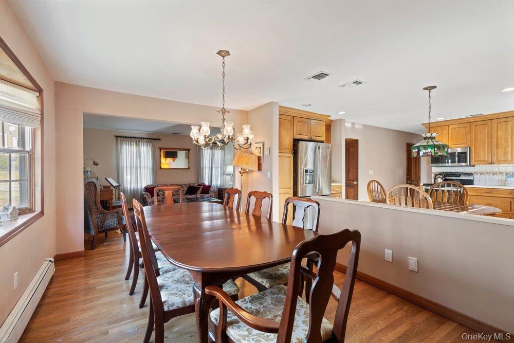 18 Barry Lane Syosset, NY 11791 - Photo 11 of 37 a view of a dining room and livingroom with furniture wooden floor a chandelier