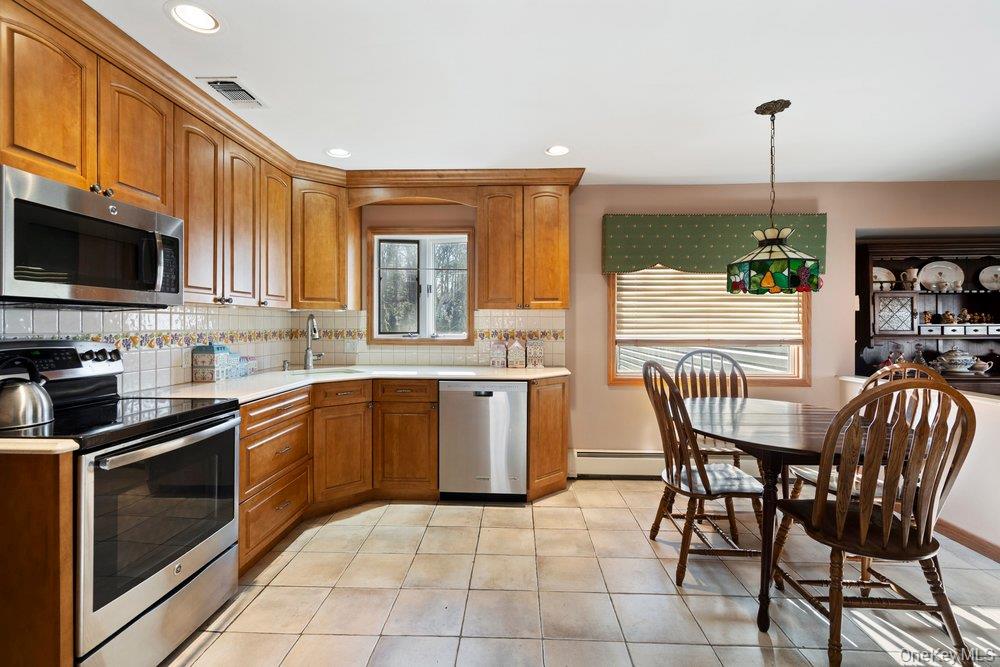 18 Barry Lane Syosset, NY 11791 - Photo 15 of 37 a kitchen with a stove a sink and a microwave