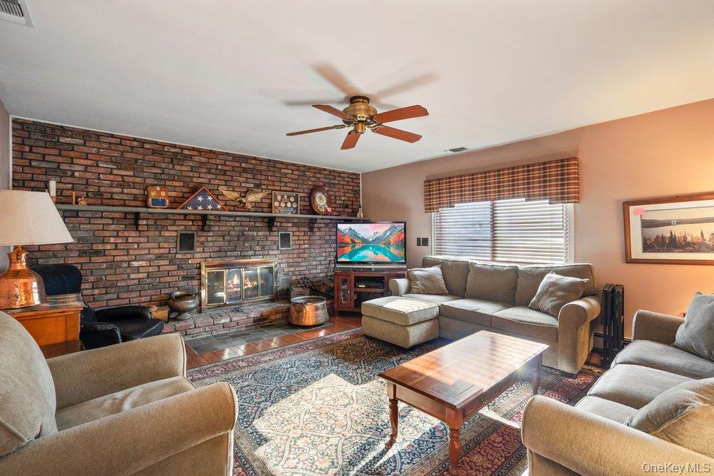 18 Barry Lane Syosset, NY 11791 - Photo 19 of 37 a living room with furniture a fireplace and a flat screen tv
