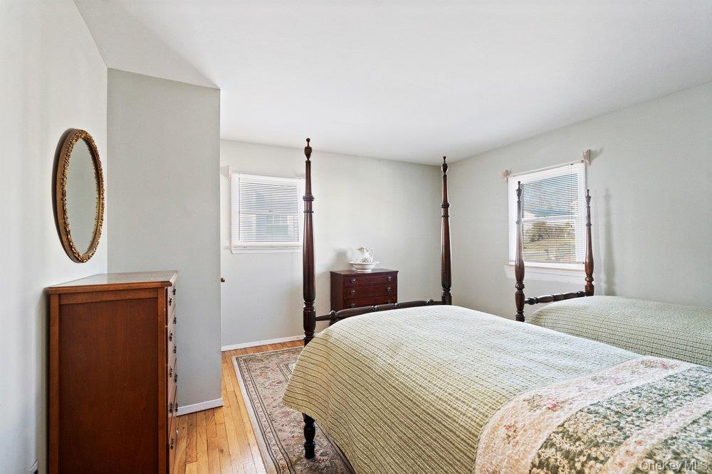 18 Barry Lane Syosset, NY 11791 - Photo 32 of 37 a bedroom with a bed and a dresser next to a window