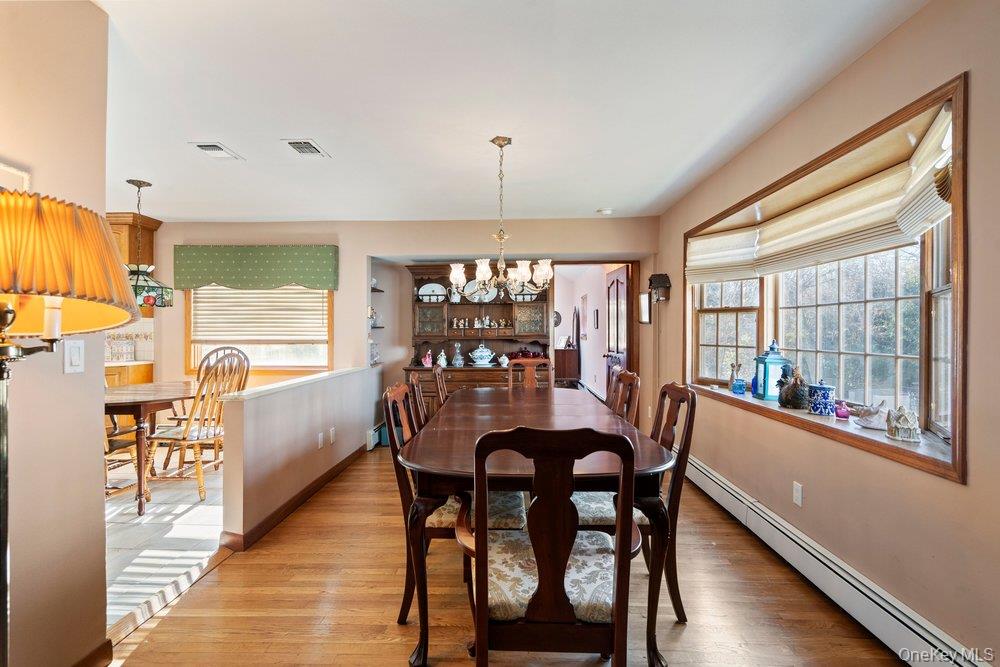 18 Barry Lane Syosset, NY 11791 - Photo 10 of 37 a dining room with furniture a chandelier and wooden floor