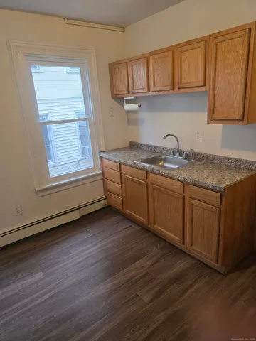 a kitchen with stainless steel appliances granite countertop a sink window and cabinets