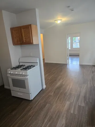 a kitchen with granite countertop a stove and a wooden floors