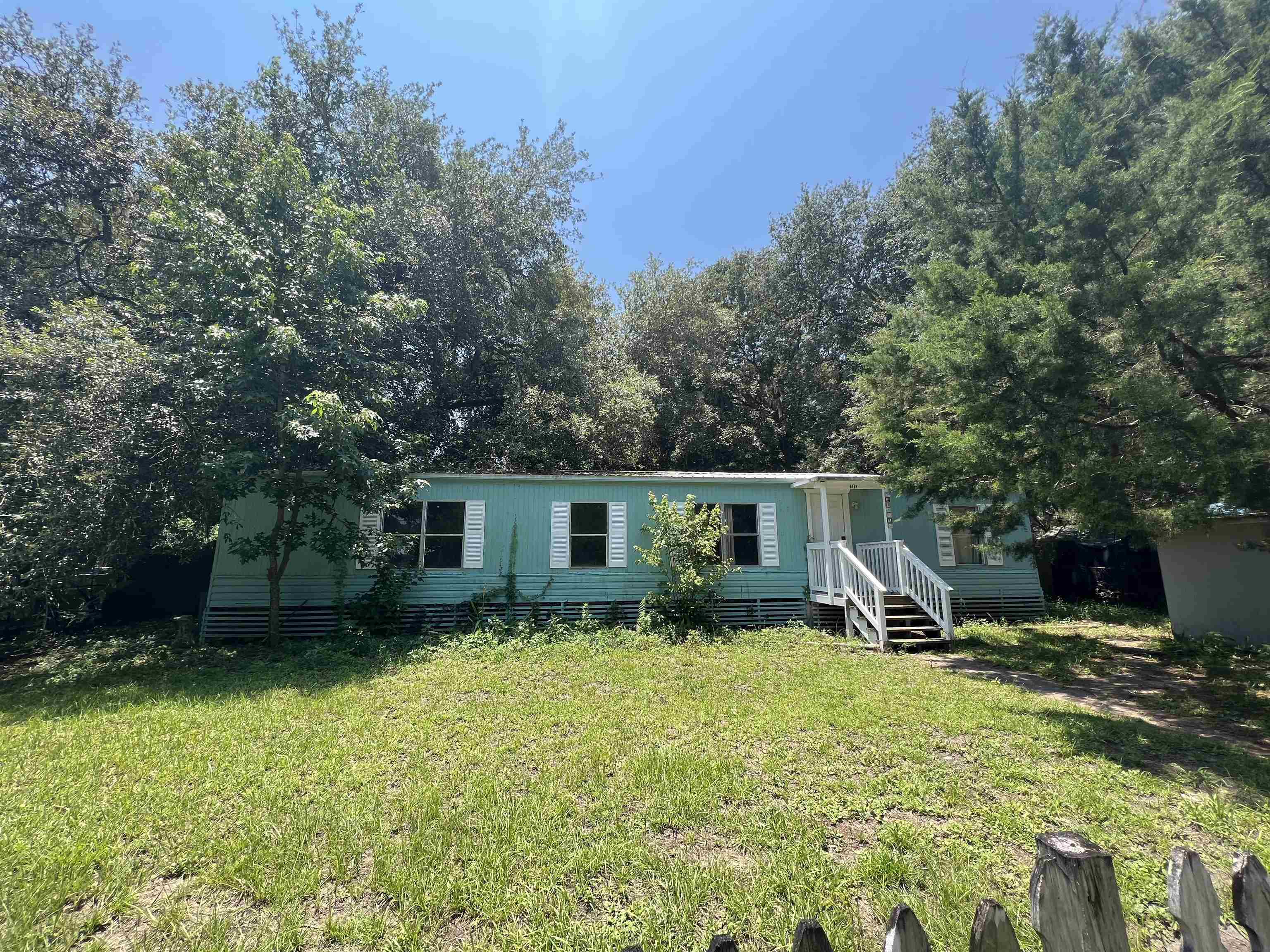 a view of a house with backyard and trees