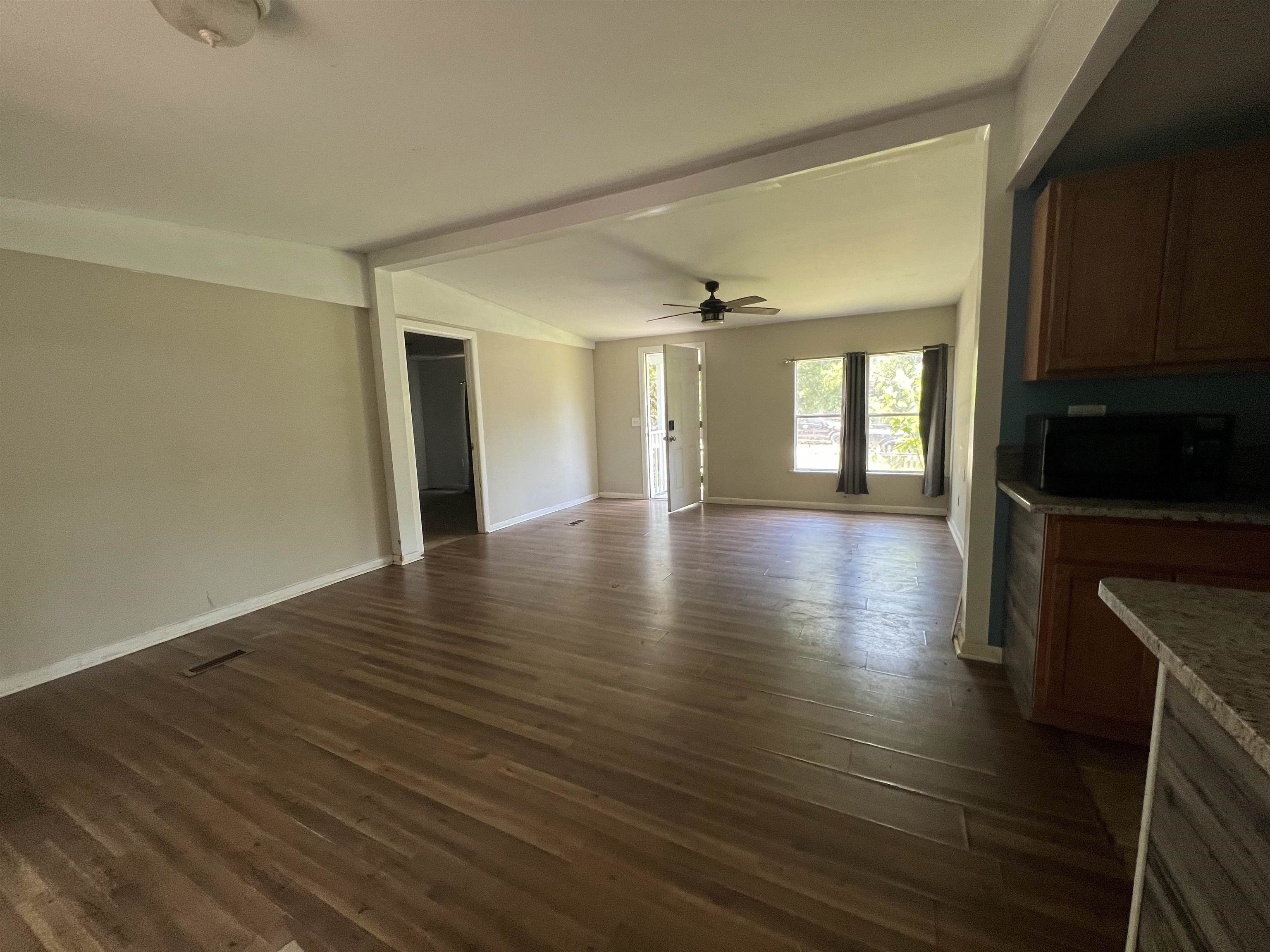 6473 Capri Isle St. Augustine, FL 32095 - Photo 4 of 7 a view of an empty room with wooden floor and a fireplace