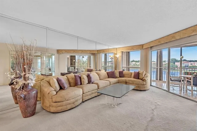 a view of a hallway with wooden floor and a living room
