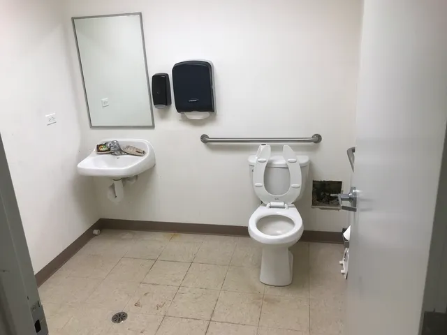 a bathroom with a toilet sink and mirror