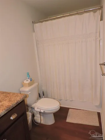 a white toilet sitting next to a shower curtain