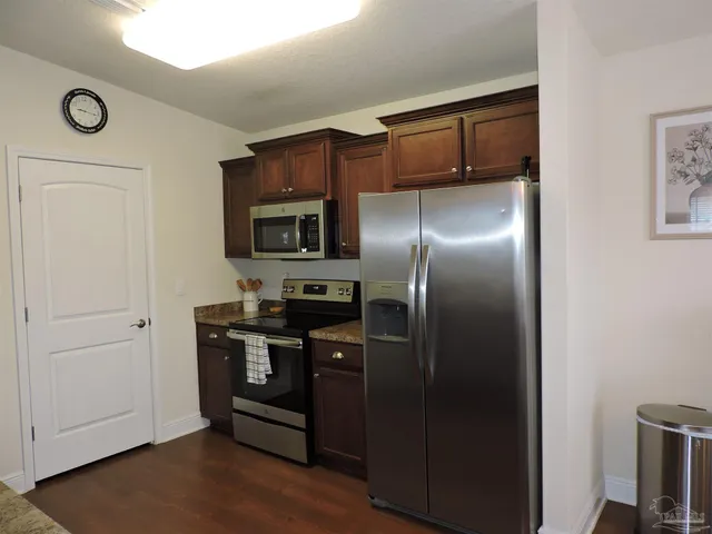 a kitchen with stainless steel appliances granite countertop a refrigerator and a stove top oven