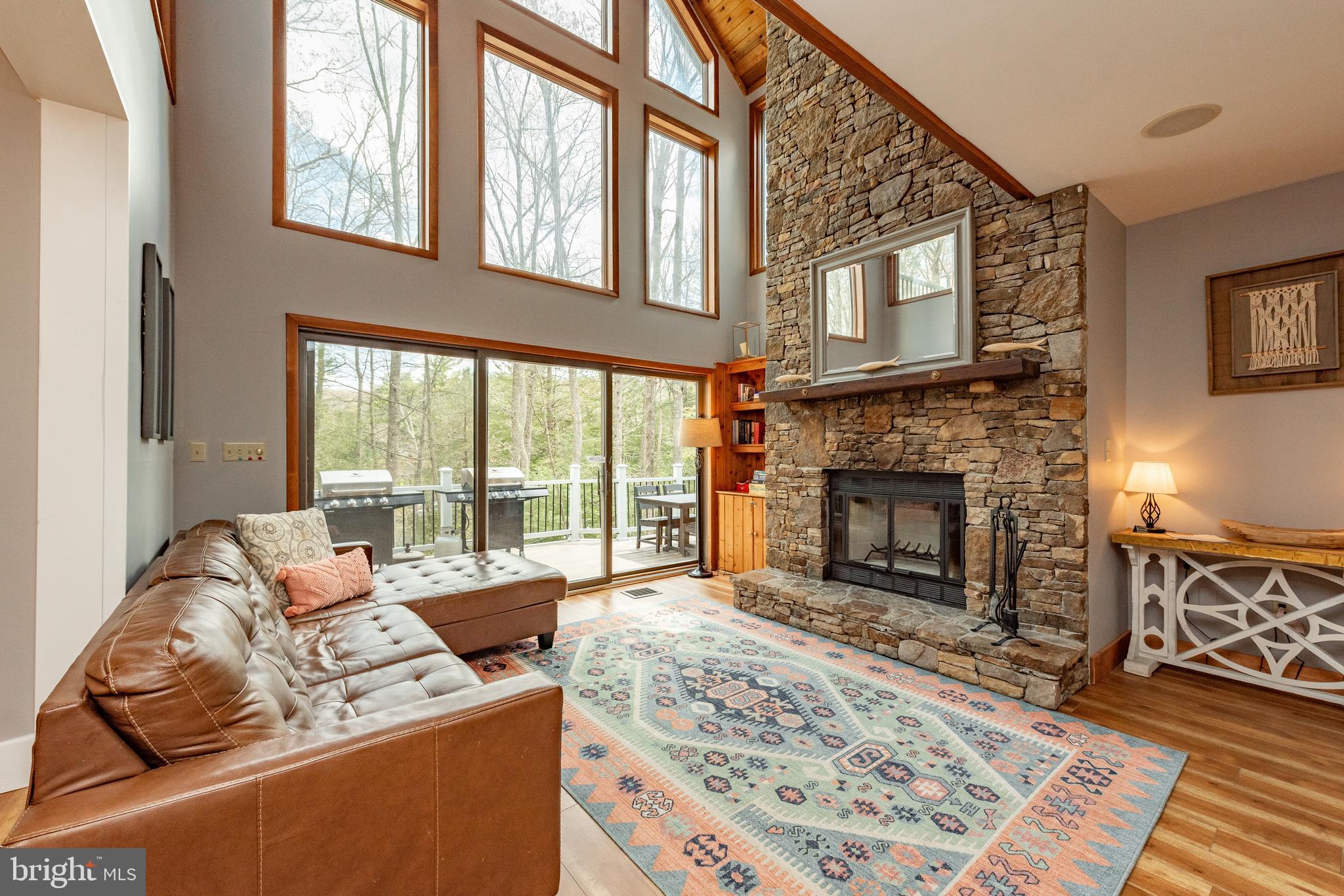 2463 Mayhew Inn Road Oakland, MD 21550 - Photo 23 of 144 a living room with furniture a rug a fireplace and a large window