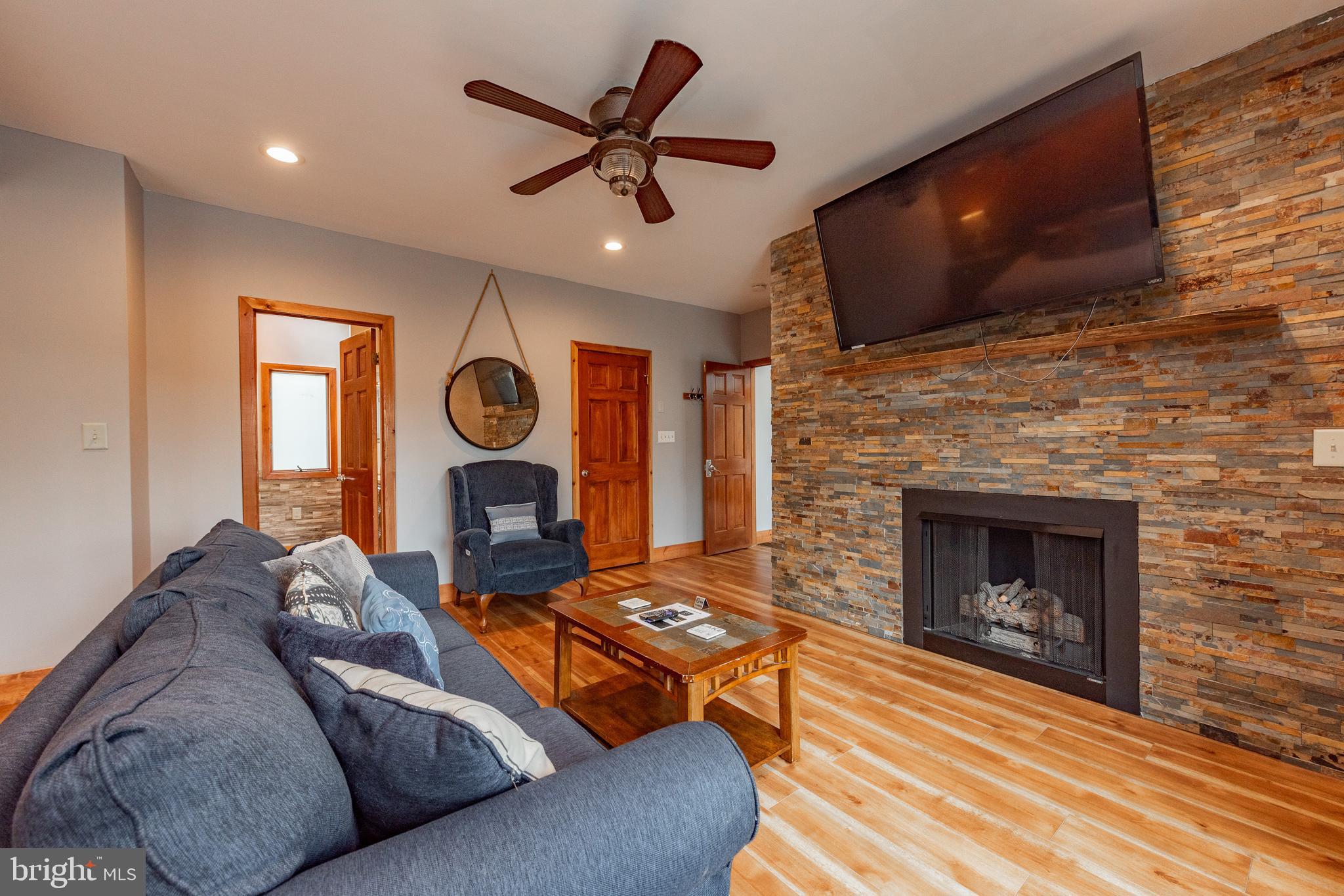 2463 Mayhew Inn Road Oakland, MD 21550 - Photo 38 of 144 a living room with furniture a flat screen tv and a fireplace