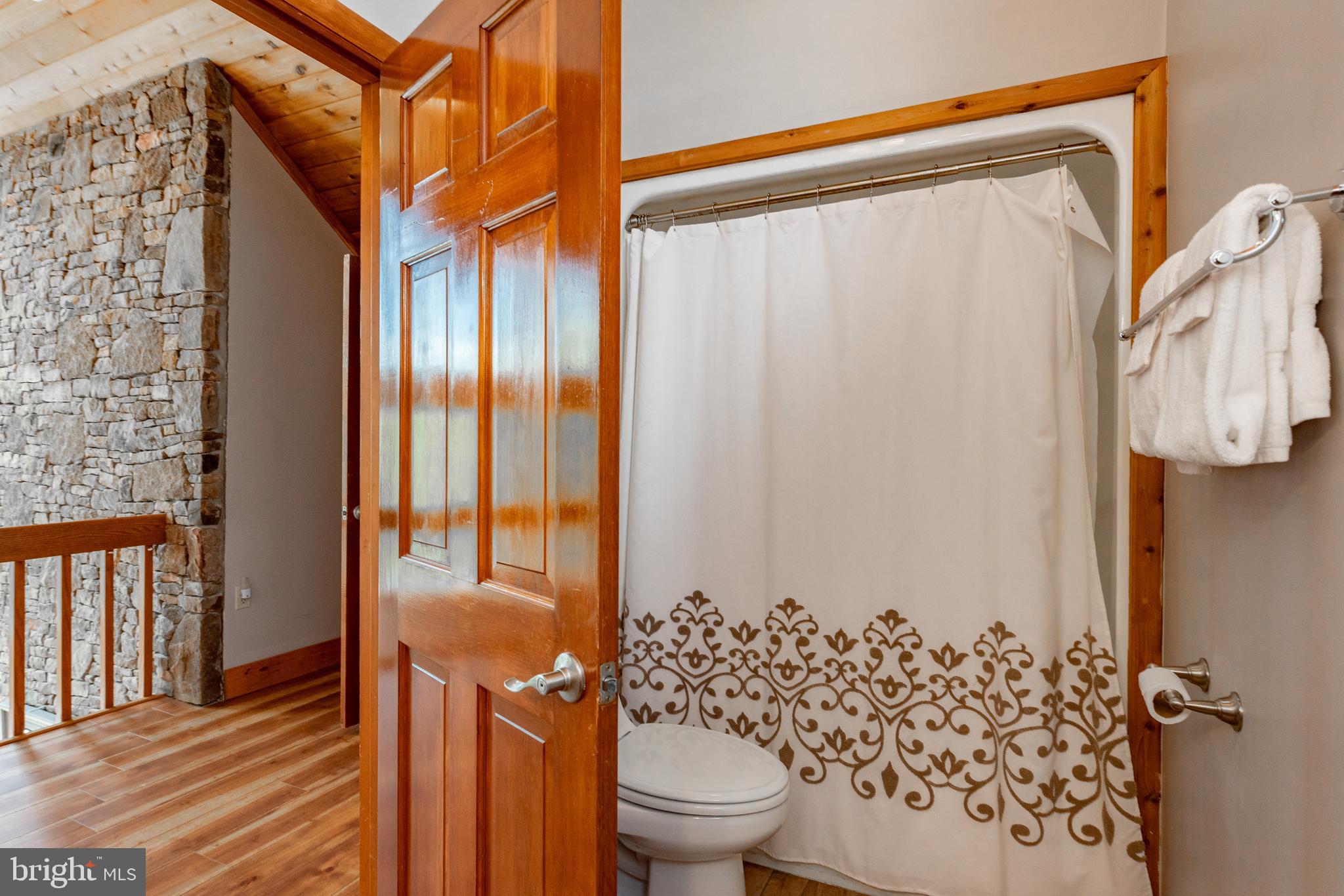 2463 Mayhew Inn Road Oakland, MD 21550 - Photo 57 of 144 a bathroom with a shower curtain and a toilet