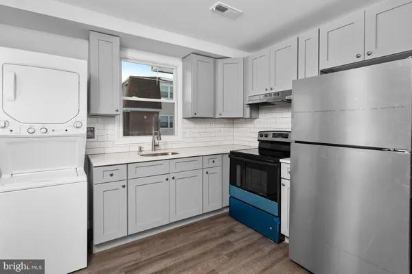 a kitchen with stainless steel appliances a refrigerator sink and cabinets