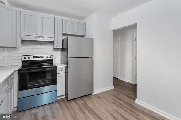 a kitchen with a white stove and white cabinets
