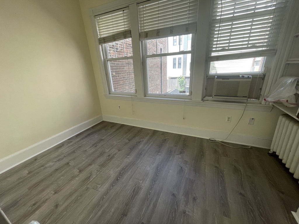 96 St Paul Street, Unit 2 Brookline, MA 02446 - Photo 13 of 14 an empty room with wooden floor and windows