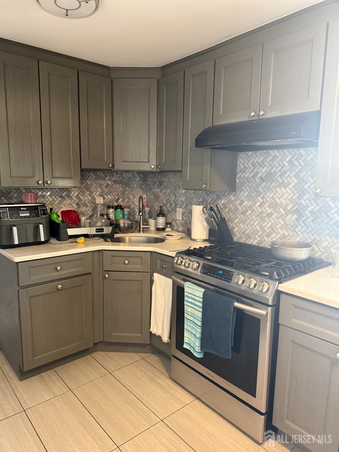 31 Edwin Street Carteret, NJ 07008 - Photo 14 of 18 a kitchen with stainless steel appliances granite countertop a stove a sink and a white cabinets