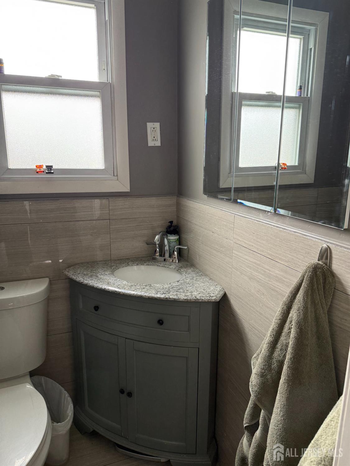 31 Edwin Street Carteret, NJ 07008 - Photo 8 of 18 a bathroom with a granite countertop toilet sink and mirror