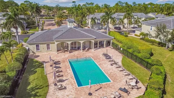an aerial view of a swimming pool with lawn chairs