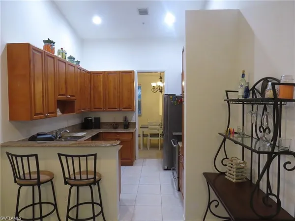 a kitchen that has a table chairs and a refrigerator