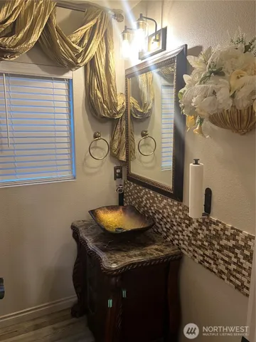 a bathroom with a granite countertop sink and a mirror