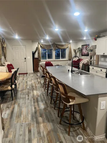 a living room with furniture a dining table and chairs with wooden floor